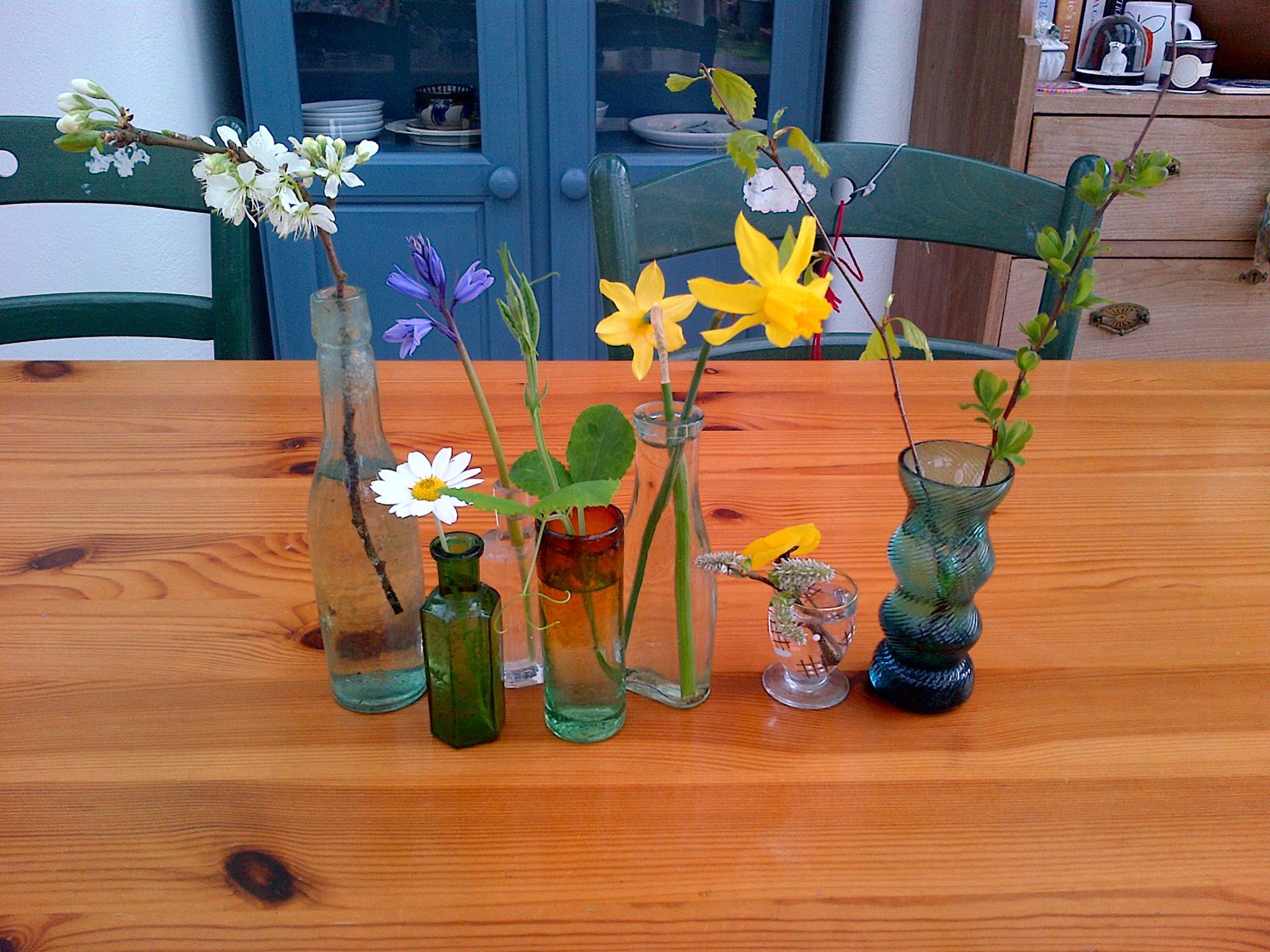 several small vases with flowers sat on a table