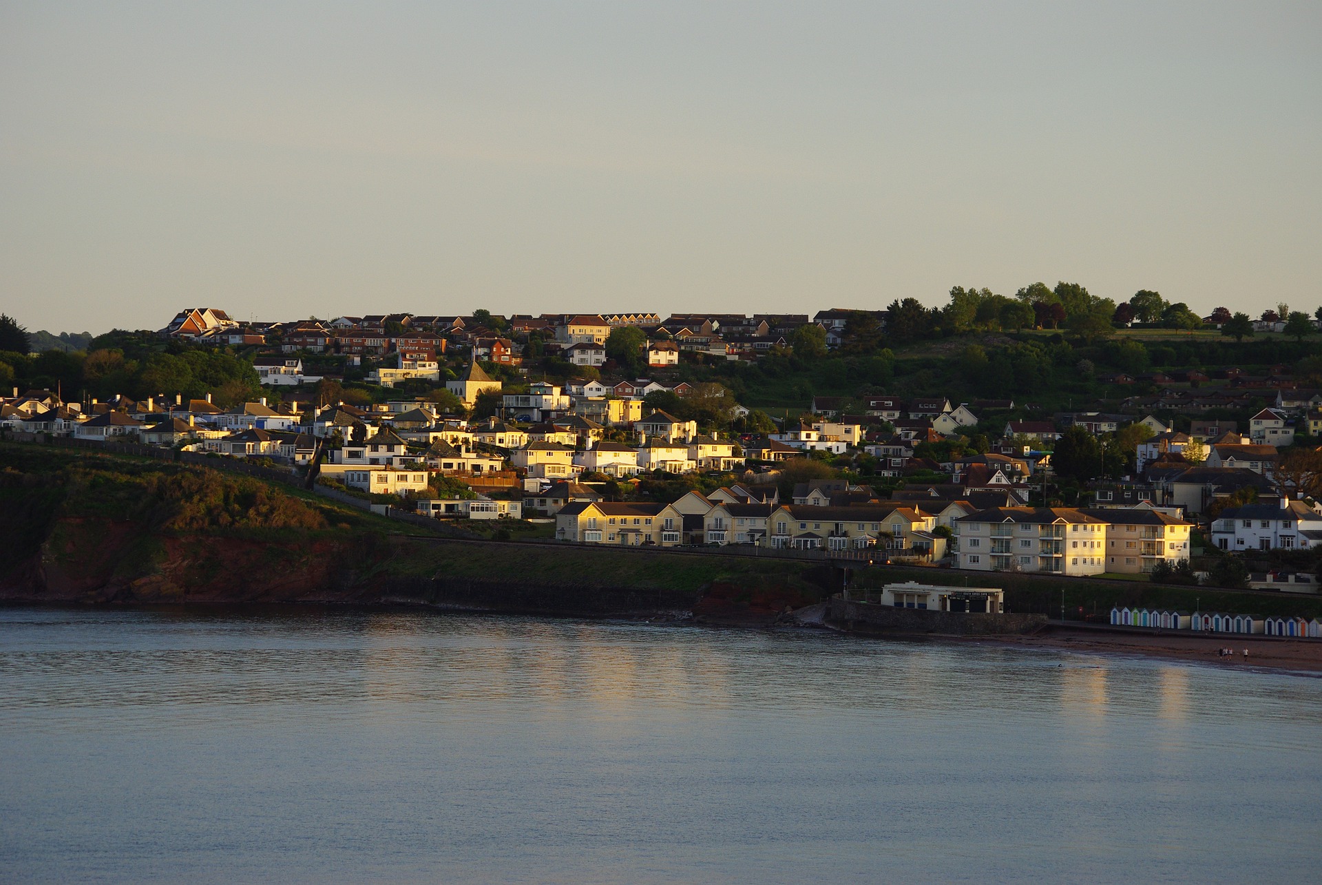 Image of housing in Paignton, Devon at dusk, looking back at the coast from the sea